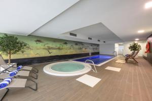 塞图巴尔塞图巴尔美利亚酒店的一间设有游泳池的客房,墙上挂有绘画作品