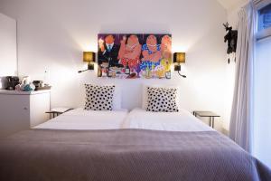 泽芬贝亨Mariafarm的卧室配有一张床,墙上挂有绘画作品