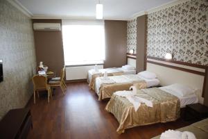 锡利夫里Safir Hotels Silivri的酒店客房,设有三张床和一张桌子及椅子