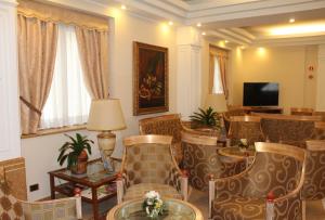 米兰莫扎特酒店的客厅配有椅子、桌子和电视
