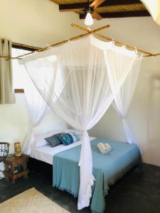 大塞拉Aruanã - Praia do Sargi的一间卧室配有一张带蚊帐的床