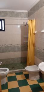 Lucena del PuertoCortijo Los Conquistadores的浴室设有2个卫生间和黄色的浴帘