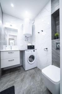 拉多姆Apartment Le Château的白色的浴室设有洗衣机和水槽。