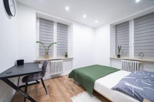 拉多姆Apartment Le Château的卧室配有一张床、一张书桌和窗户。