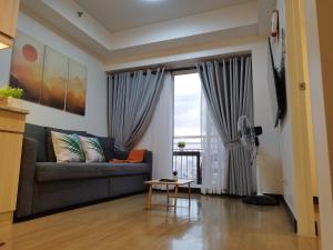 马尼拉CELANDINE Residence by DMCI的带沙发和窗户的客厅