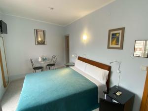 锡切斯Hotel Alexandra Sitges的酒店客房带一张床、一张桌子和椅子