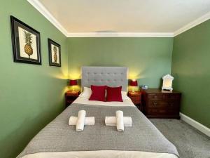 布莱顿霍夫Regency Apartment - Marine Square By Crown Gardens Holiday Homes的绿色卧室配有一张带红色枕头的大床