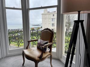布莱顿霍夫Regency Apartment - Marine Square By Crown Gardens Holiday Homes的椅子坐在带窗户的房间
