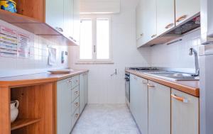 托雷瓦多Villetta Maredorat Vista Mare by HDSalento的白色的厨房设有水槽和炉灶。