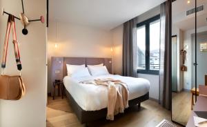 安锡Hébé Hotel的酒店客房设有一张床和一个大窗户