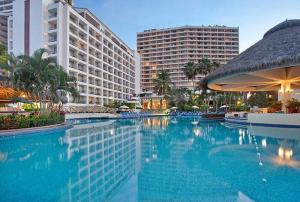 巴亚尔塔港Beachfront Resort Condo beside la Isla Mall的一座大型游泳池,位于拥有建筑的度假胜地