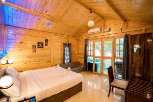 阿贡达orange sky beach bungalow的木制客房内的一间卧室,配有一张床