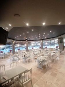 锡利夫里Safir Hotels Silivri的大型用餐室配有桌子和白色椅子