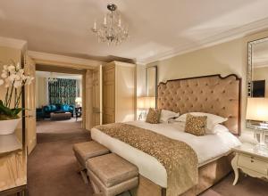 伦敦斯隆俱乐部公寓的一间卧室配有一张大床和一个吊灯。