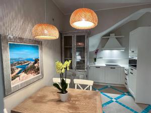 皮诺港Villa Aquamarina Pavoncella Rossa的厨房配有两盏灯,餐桌上摆放着鲜花