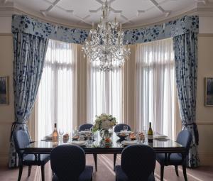 伦敦斯隆俱乐部公寓的一间带桌椅和吊灯的用餐室