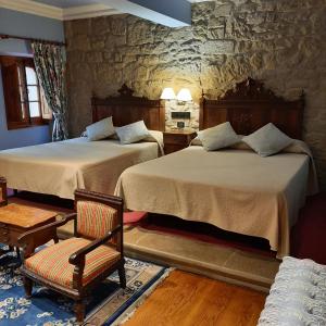 拉瓜迪亚科亚多城堡酒店的一间卧室配有两张床和椅子
