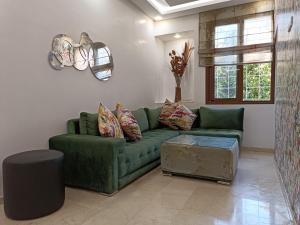 卡萨布兰卡Luxury Family House with Garden View Casablanca的客厅配有绿色沙发和桌子