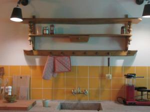 EsbeekZintuinen的厨房配有水槽和墙上的架子
