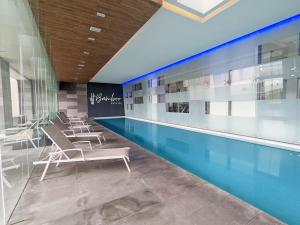 墨西哥城Luxury Condo Santa Fe Cosmocrat By Bamboo Skylife的游泳池旁带椅子的游泳池