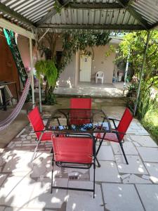 科马亚瓜Aparta Hotel Palmerola的庭院里一组红色的椅子和一张桌子