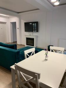 普雷代亚尔HAPPY SUMMER -Predeal的客厅配有白色桌子和蓝色沙发