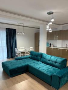 普雷代亚尔HAPPY SUMMER -Predeal的客厅设有蓝色沙发,配有厨房