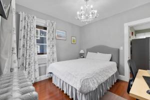 波士顿Bright & Spacious 2Br apartment, mins from Downtown Boston, parking的白色卧室配有一张床和一个吊灯