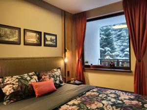 波罗维茨Pinewood ANG luxurious apartment A32的一间卧室设有一张床和一个白雪 ⁇ 的窗户
