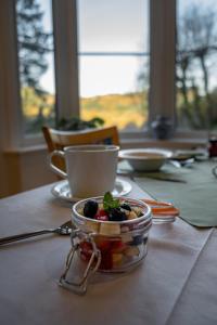 贝图瑟科伊德格林旺格住宿加早餐旅馆的桌上放着一碗水果和一杯咖啡