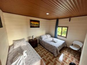 蒙泰韦尔德哥斯达黎加Bonanza的小房间设有两张床和窗户