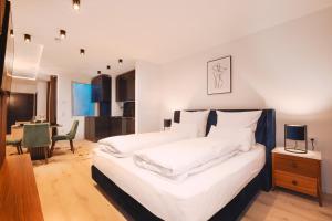 谢尔丁Loft Suite im modernen Style in Schärding的一间卧室配有一张带白色床单和一张桌子的床。