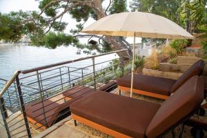 邦多勒Splendid Hôtel & Spa的一个带椅子和遮阳伞的临水露台
