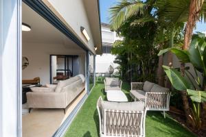 里雄莱锡安O&O Group - Huge Villa With Jacuzzi By The Beach的室外庭院设有桌椅和草地。