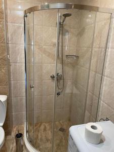 普里莫尔斯科Deluxe Apartments Приморско的设有带卫生间的浴室内的淋浴间