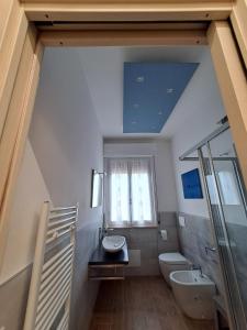 帕尔马Casa Mirò的一间带水槽和卫生间的浴室以及窗户。
