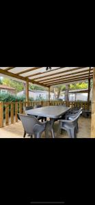 圣西普里安MOBIL-HOME NEUF 2021 3CH 34 M2的木甲板上的桌椅