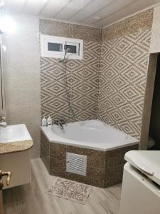 康斯坦丁Appartement F4 de Luxe的带浴缸和盥洗盆的浴室