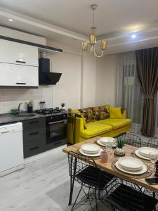 BurunabatNur-Ella House的客厅配有黄色的沙发和桌子