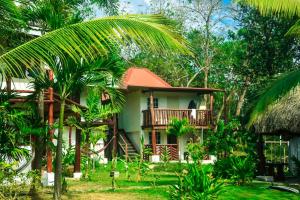 普拉纳维瑙La Choza Playa Venao的带阳台和棕榈树的热带度假屋