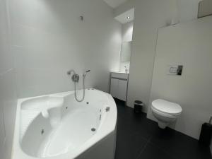 佩塔提克瓦Rothschild 79的白色的浴室设有浴缸和卫生间。