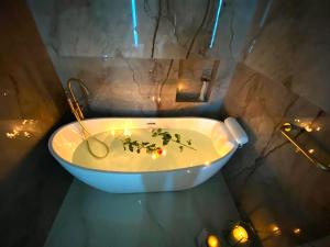 凯撒利亚Rose Suite的浴室配有带蜡烛和灯的浴缸。