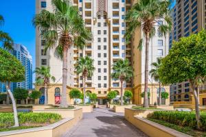 迪拜Lovely 2-bed condo in JBR - 5 mins from beach - Palm View!的一条拥有棕榈树和建筑的城市街道
