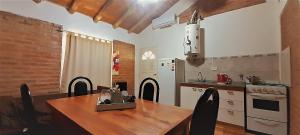 波特雷罗德洛斯弗内斯Cabañas Espejo del Cielo的设有带木桌和椅子的厨房以及带