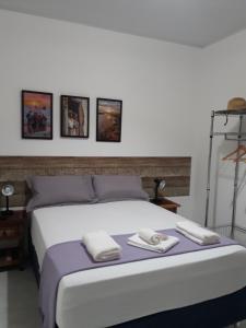 佩德拉斯港Marezal Suítes的一间卧室配有一张床,上面有两条毛巾