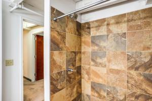 罗切斯特Centric Modern Loft w/ King Beds & Smart GameTable的带淋浴的浴室(带石墙)