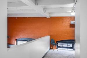 罗切斯特Centric Modern Loft w/ King Beds & Smart GameTable的一个带椅子的房间的橙色砖墙
