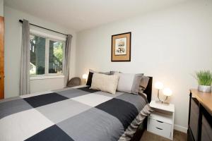 惠斯勒Gondola Haus - Free parking的卧室设有黑白床和窗户。