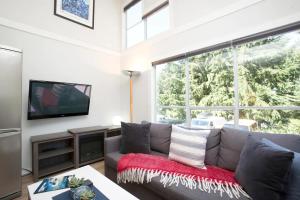 惠斯勒Gondola Haus - Free parking的客厅设有灰色的沙发和大窗户