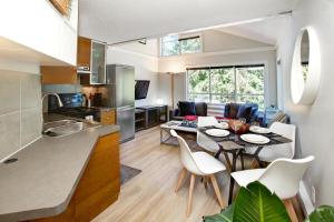惠斯勒Gondola Haus - Free parking的厨房以及带桌椅的起居室。